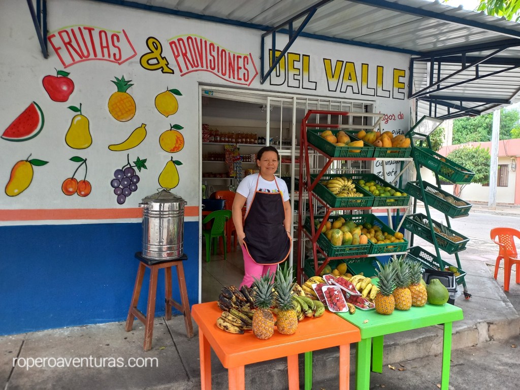 Mujer vendedora de frutas tropicales en su tienda.