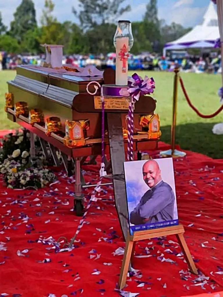 Funeral de un sacerdote católico con su fotografía al frente del ataúd.